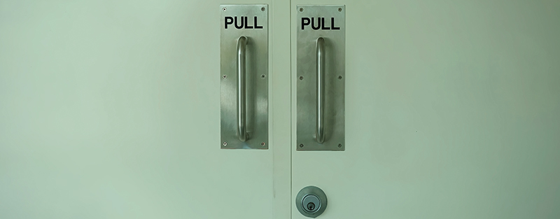 Two doors with handles that say Pull.